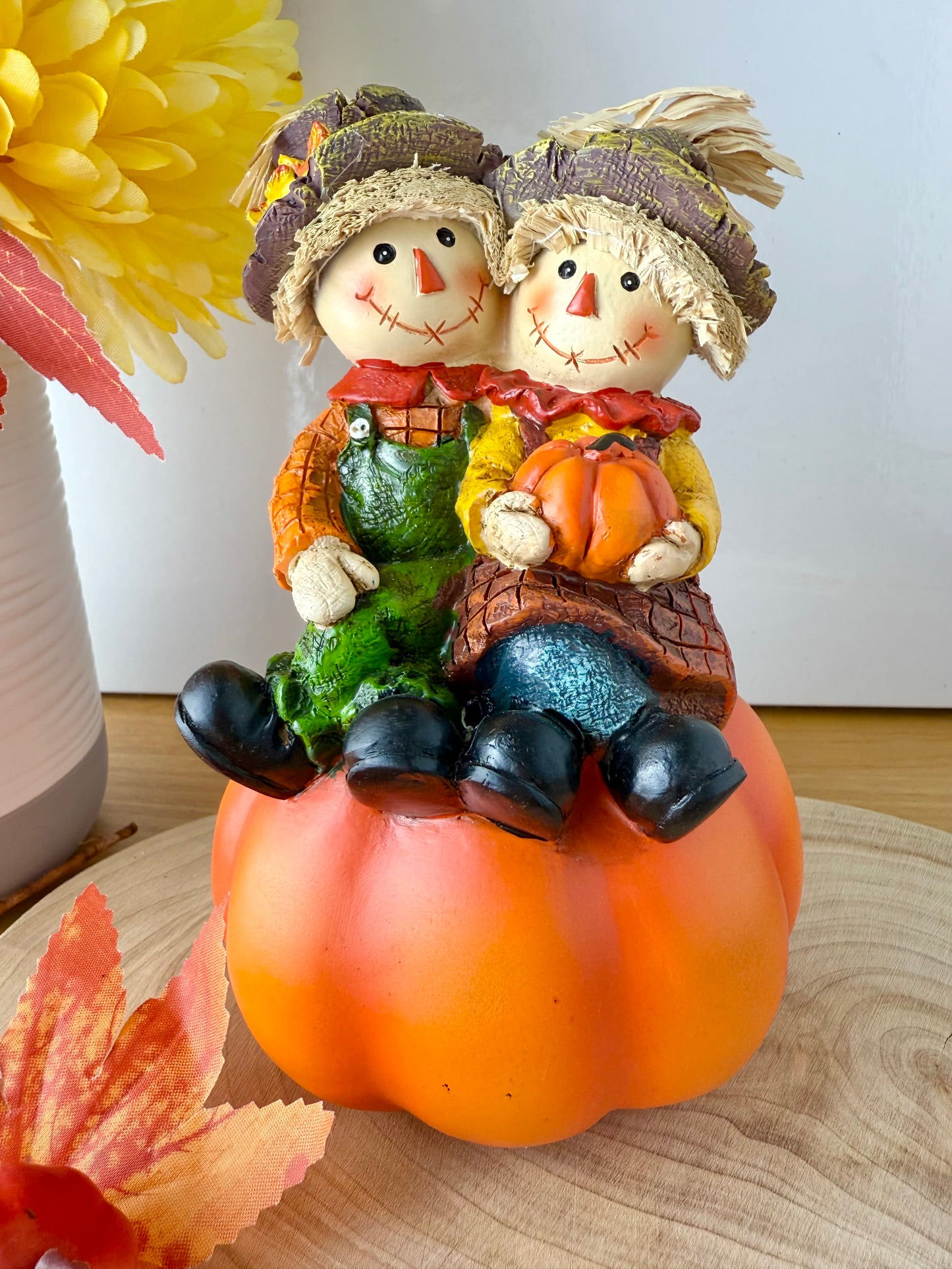 Harvest Scarecrow couple sat on a pumpkin