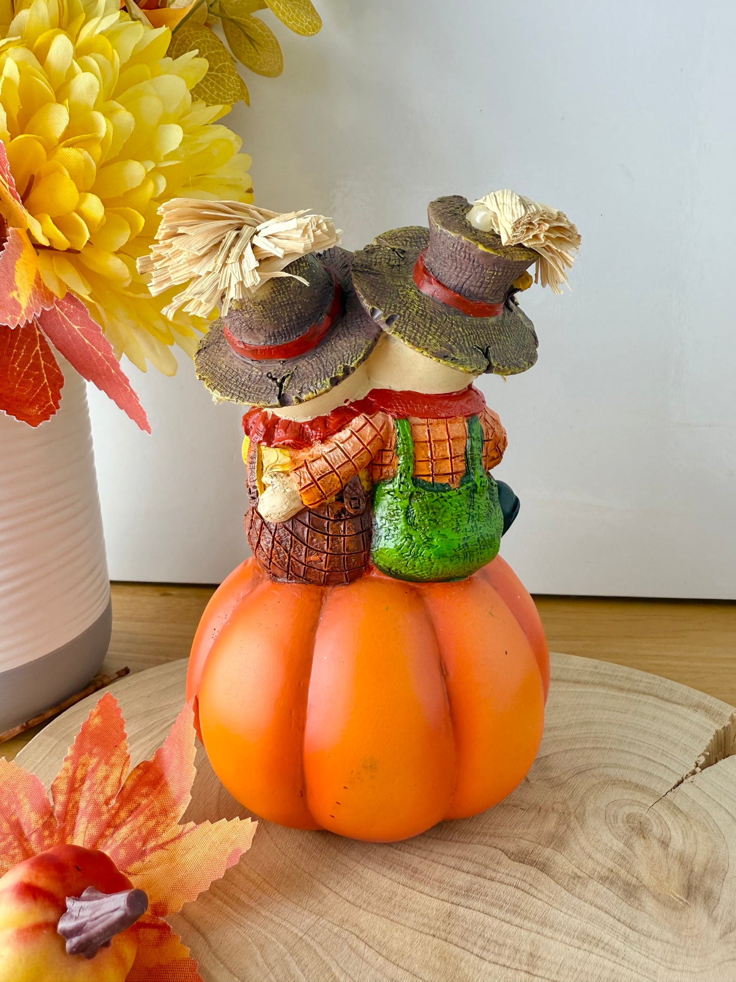 Harvest Scarecrow couple sat on a pumpkin